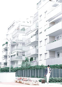 Person Standing In Front Of White Buildings thumbnail