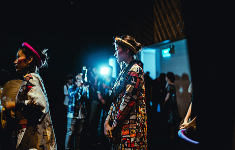 Several female model in costume about to go on stage thumbnail
