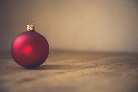 red Christmas ball decor on brown surface thumbnail