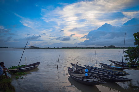 wooden paddle boats under cloudy sky thumbnail
