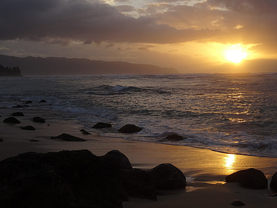 body of water crashing on sand during golden hour thumbnail