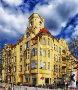 yellow high-rise building under cloudy sky at daytime thumbnail