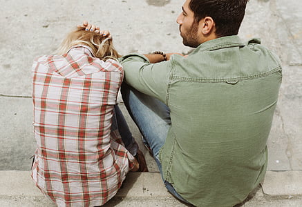two person sitting on pavement during daytime thumbnail
