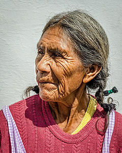 woman in yellow and red knit top near white painted wall thumbnail