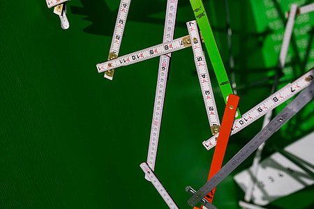 Extandable wooden ruler on a green background thumbnail