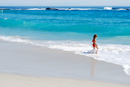 girl walking towards sea water taken at daytime thumbnail