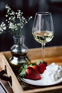 Strawberries with cream and glass of white wine on wooden tray thumbnail