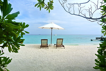 two lounge chair under umbrella on seashore thumbnail
