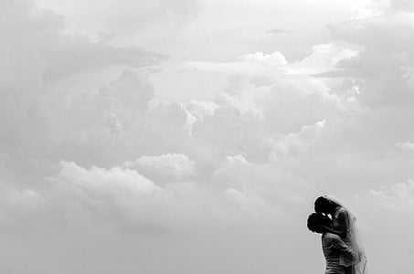 man carrying woman on clouds during daytime thumbnail