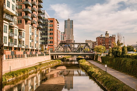 body of water under bridge near buildings at daytime thumbnail