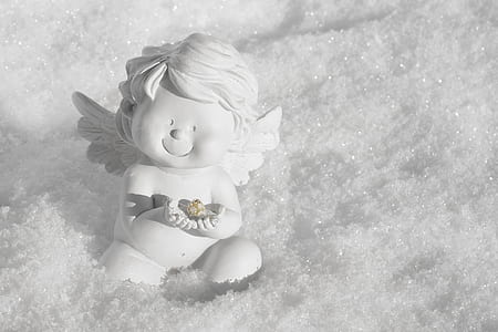 cherub white ceramic figurine sitting on the snow thumbnail