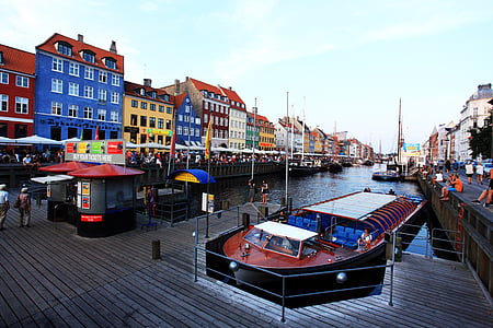 brown wooden boat between buildings during daytime thumbnail