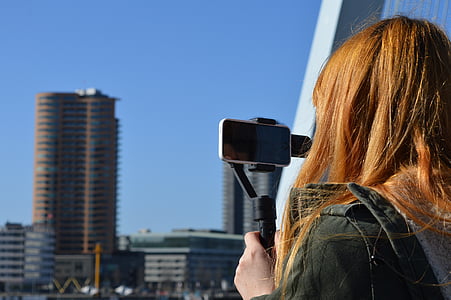 photo of woman holding black stabilizer with silver Android smartphone thumbnail