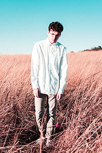 man standing on brown field during daytime thumbnail