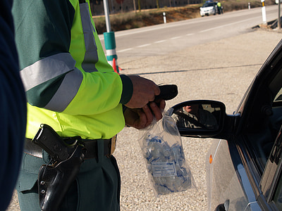 man in green uniform facing in front of car thumbnail