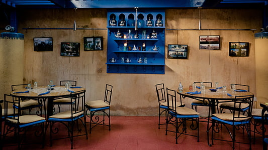 two round brown wooden dining sets on red floor tiles in room interior thumbnail