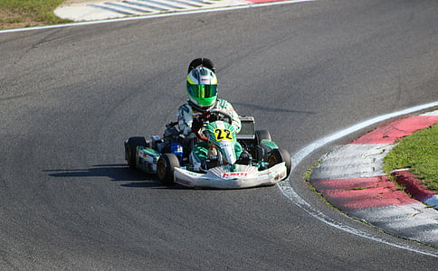 man riding green go-kart in racing track thumbnail