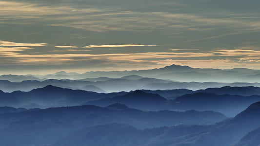 aerial view photography of mountains covered by fog under cloudy sky thumbnail
