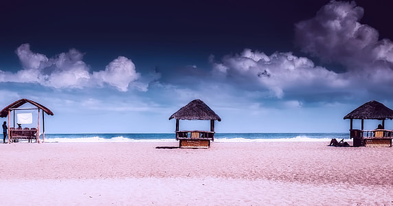 three brown hut near beach shore thumbnail