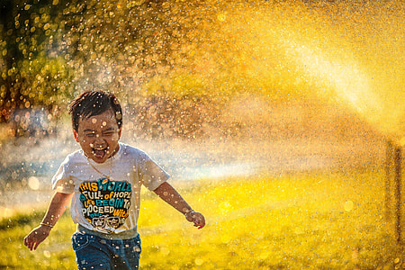 boy playing near outdoor fountain thumbnail