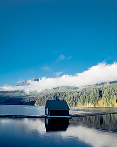 brown and gray boat house under blue sky thumbnail
