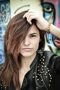 woman in black leather collared top holding head thumbnail