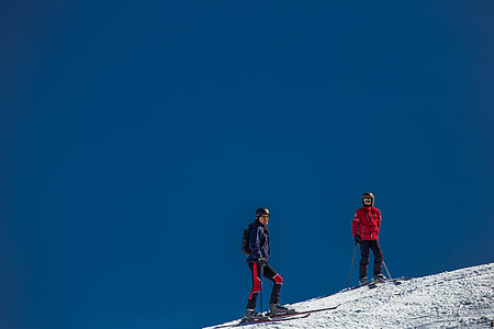 two persons standing on snow-covered slope thumbnail