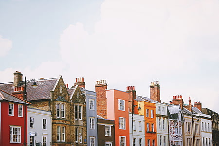 assorted-color concrete buildings under white clouds at daytime thumbnail