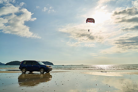 blue 5-door hatchback on seashore thumbnail