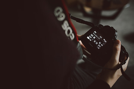 close up photo of person holding black camera thumbnail