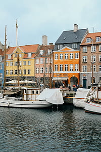 boats on body of water near houses during daytime thumbnail