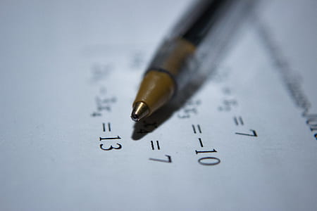 selective focus photography of black ball-point pen on top of paper with mathematical equations thumbnail
