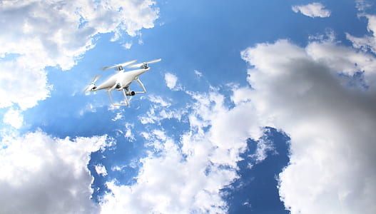 white DJI drone under white clouds and blue sky at daytime thumbnail