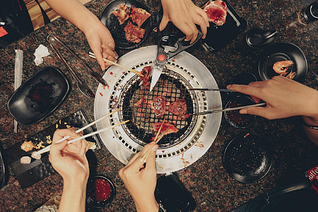 group of five people grilling meat in tabletop grill thumbnail