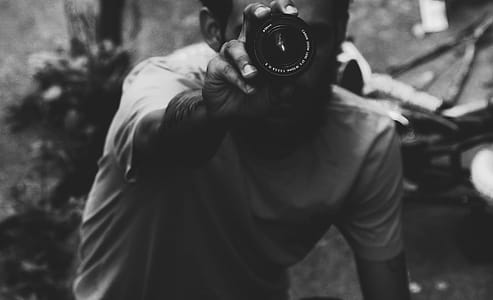 Man Wearing Shirt Holding Up Camear thumbnail