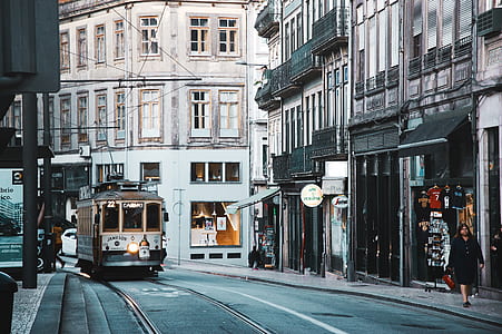 photo of white and brown train beside white and grey concrete buildings thumbnail