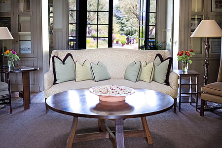 beige floral sofa in front of round brown wooden coffee table thumbnail
