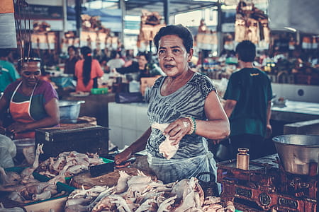 Woman in Gray Shirt Holding a Chicken Piece thumbnail