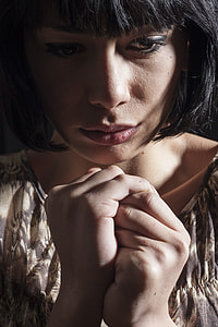 woman in brown and black floral top holds her hand tight thumbnail