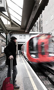 time lapse photography of man standing in front of train thumbnail
