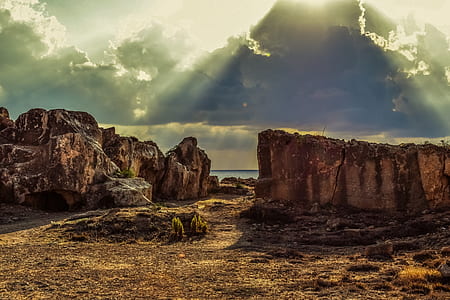 brown cliff near a sea under grey cloudy sky thumbnail