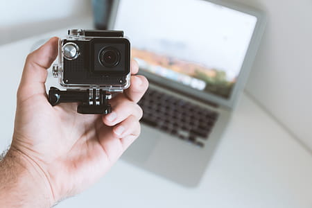 Modern small sport and outdoor camera in the hand of man at office thumbnail
