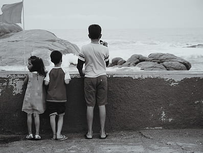 boy in white shirt near ocean thumbnail