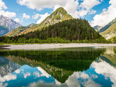 mountain near lake under cloudy sky thumbnail