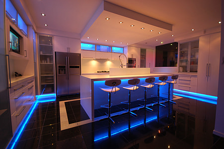 white wooden kitchen with blue LED strips surrounded on corners at night time thumbnail