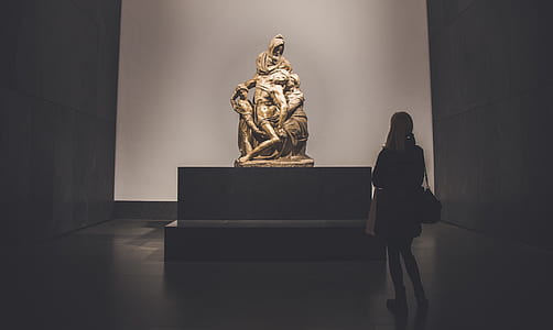 woman standing in front of golden statue thumbnail