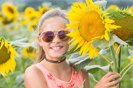 woman wearing sunglasses holding sunflower thumbnail
