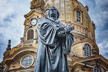 man holding book statue near building thumbnail