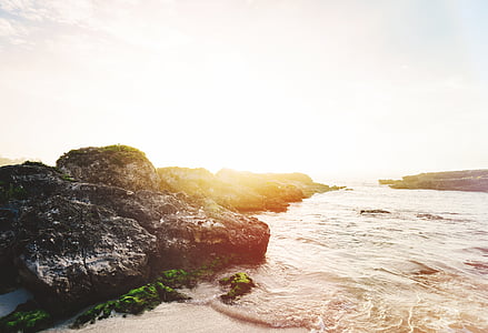 silhouette photo of rock formations facing body of water thumbnail
