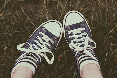 person's feet on grass field thumbnail